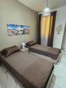 two beds sitting next to each other in a bedroom at Sun Sea Living Gozo in Xlendi