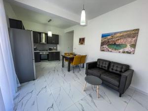 a living room with a couch and a table at Sun Sea Living Gozo in Xlendi