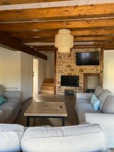 sala de estar con sofás blancos y chimenea en EL PAJAR DE LEONOR, en Horcajuelo de la Sierra