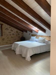 um quarto com uma grande cama branca num sótão em EL PAJAR DE LEONOR em Horcajuelo de la Sierra