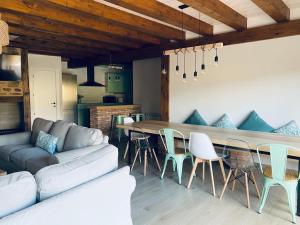 a living room with a couch and a table and chairs at EL PAJAR DE LEONOR in Horcajuelo de la Sierra