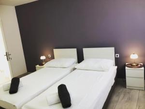 2 camas individuales en una habitación con 2 lámparas en Apartman Bloom, en Osijek