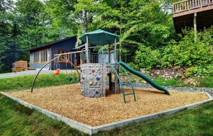 a playground with a slide in a yard at Chalets Alpins - 12 Chemin Alpin in Stoneham