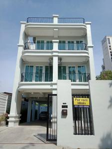 Un edificio blanco con un cartel delante. en TEAK VILLA, en Bangna