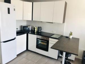 a kitchen with white cabinets and a black counter top at Perla de Amadores in Amadores