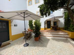 a patio with a table and an umbrella at Casa Carmo in Évora