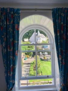 an arched window with a view of a house at Leven House Bed and Breakfast in Crieff