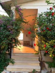- l'entrée d'une maison ornée de fleurs et d'escaliers dans l'établissement Affittacamere Ternulla, à Rosolini