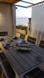uma mesa de madeira com pratos e copos de vinho em Casa Marianne em Donnalucata