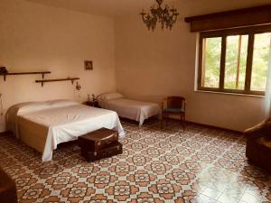 - une chambre avec 2 lits et une valise à l'étage dans l'établissement Affittacamere Ternulla, à Rosolini