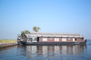 Na wodzie zacumowana jest łódź. w obiekcie Sreekrishna Houseboat - VACCINATED STAFF w mieście Kumarakom