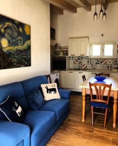 a living room with a blue couch and a kitchen at B&B Casa Vacanza Centro Sardegna in Sorgono