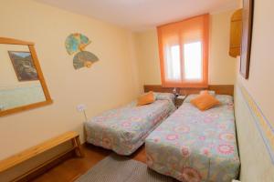 een slaapkamer met twee bedden en een raam bij Casa Maria Jesus in Mosqueruela