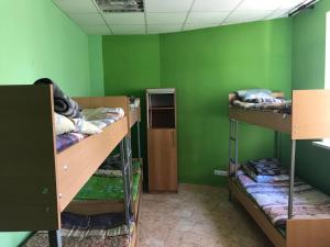 a room with three bunk beds and a green wall at Arcobaleno Home in Kyiv