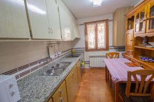 een keuken met een wastafel en een tafel. bij Casa Maria Jesus in Mosqueruela