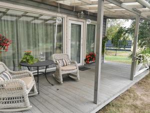 a screened in porch with wicker chairs and a table at Holiday Home Kolka in Kolka