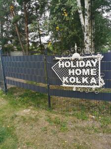a blue fence with a happy home koko sign on it at Holiday Home Kolka in Kolka