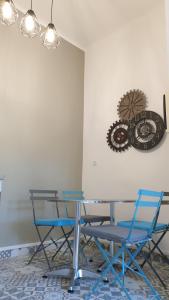 un comedor con sillas y un reloj en la pared en Marseille 6ème Vauban élégant T3 6 couchages 2 chambres, en Marsella