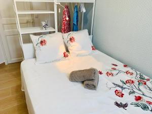 Una cama con sábanas blancas y flores rojas. en Marseille 6ème Vauban élégant T3 6 couchages 2 chambres, en Marsella