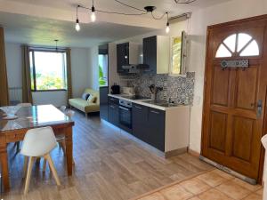 a kitchen with a table and a dining room at Charmant rez de villa en provence in Le Tignet