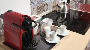 Una cafetera roja sentada en un mostrador con tazas en Domus Solarii Holiday Home en Bergamo