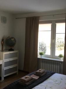 a bedroom with a bed and a window with towels on it at Lorin Prestige Apartament in Elblag