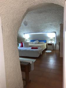 1 dormitorio con 2 camas y pared de piedra en Appartamento immerso nel cuore del parco dell Adamello, en Cimbergo