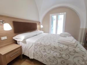 1 dormitorio con 1 cama con sábanas blancas y ventana en Opera Relais 85, en Messina