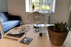 stół z kieliszkami do wina i rośliną na nim w obiekcie Cotswolds Cottage Ilmington with Wood Burning Stove & BBQ - pet friendly w mieście Chipping Campden