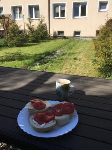 a plate with sandwiches on a table with a cup of coffee at Lorin Prestige Apartament in Elblag