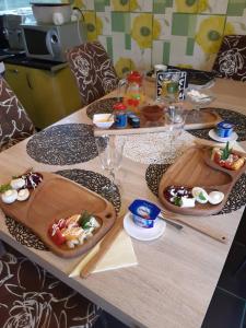 a wooden table with plates of food on it at B&B Sandra in Alūksne