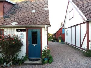 uma casa com uma porta azul num quintal em Lilla Röda Halmstadby 3524, Kågeröd em Kågeröd