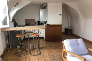 a kitchen with a counter and stools in a room at Sous les toits in Dieppe