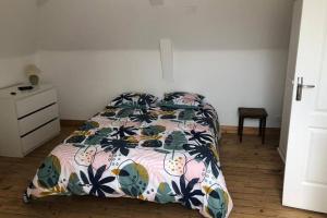 ein Schlafzimmer mit einem Bett mit einer bunten Bettdecke in der Unterkunft Sous les toits in Dieppe
