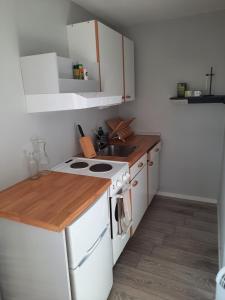 a kitchen with a white stove and a sink at Villa Gebbie in Vessigebro