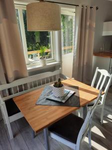 a wooden table and chairs in a kitchen with windows at Villa Gebbie in Vessigebro