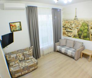 ein Wohnzimmer mit einem Sofa und Blick auf den Eiffelturm in der Unterkunft Студия Париж в Александровском саду in Adler