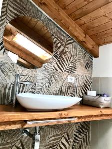 ein Badezimmer mit einem weißen Waschbecken auf einer Holztheke in der Unterkunft Sabbinirica House in Catania