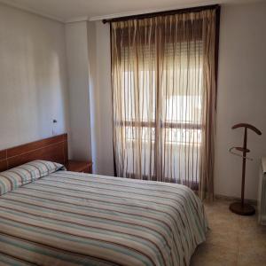 1 dormitorio con cama y ventana grande en Entre playas en Noja