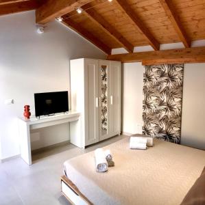 a bedroom with a bed and a flat screen tv at Sabbinirica House in Catania