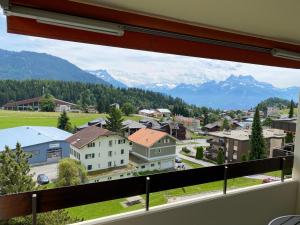 una ventana con vistas a una ciudad con montañas en Swiss Mountains, en Leysin