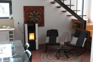 a living room with two chairs and a fireplace at Quinta Vale da Prata in Celorico da Beira