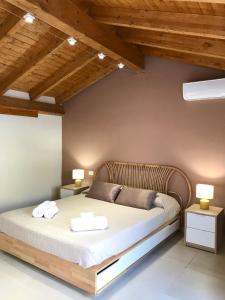 ein Schlafzimmer mit einem großen Bett mit zwei Tischen in der Unterkunft Sabbinirica House in Catania