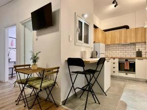 a kitchen with a table and two chairs in a room at B & B House Apartment in Athens