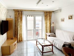 a living room with a couch and a table at Open Sky, Apartamento con solárium privado y barbacoa in El Vendrell