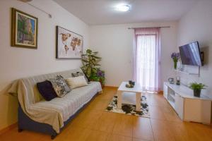 salon z kanapą i telewizorem w obiekcie Studio in Stara Baska/Insel Krk 34427 w mieście Stara Baška