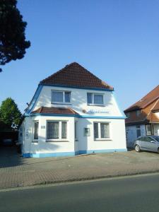 una casa blanca con techo rojo en una calle en Pension Abendsonne, en Büsum