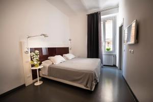 a bedroom with a bed and a window at Inn Urbe Colosseo in Rome