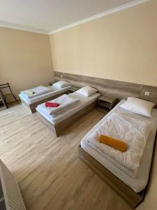 three beds in a room with wooden floors at Soso Burduli's Guesthouse in Kazbegi