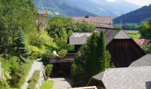 eine Aussicht über ein Haus mit Bäumen und Bergen in der Unterkunft Wohnstudio in umgebauter Scheune in Altlassing